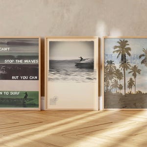 May include: Three framed wall art prints featuring surfing themes. The left print displays ocean waves and the text "YOU CAN'T STOP THE WAVES BUT YOU CAN LEARN TO SURF." The centre print shows a surfer on a wave. The right print depicts palm trees.