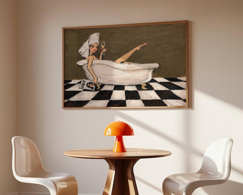 May include: A framed wall art print depicting a person with a white towel wrapped around their head, relaxing in a white clawfoot bathtub. The person holds a glass of champagne and a magazine. The floor features a black and white checkered pattern.