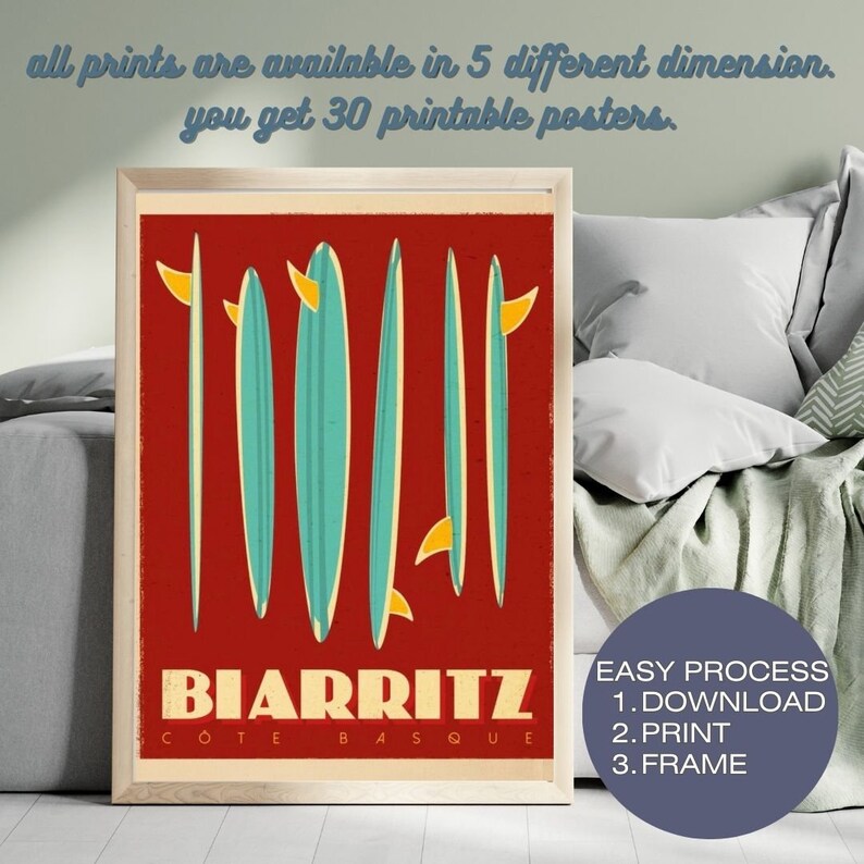 May include: A vintage-style poster with a red background featuring five surfboards with yellow fins. The text "BIARRITZ COTE BASQUE" is printed in white at the bottom of the poster. The poster is framed in a light wood frame.