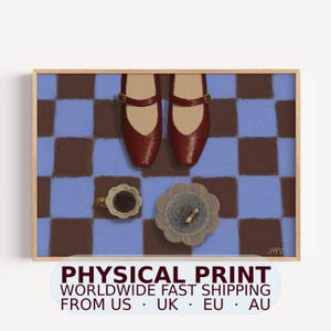 May include: A framed art print featuring a top-down view of a pair of dark red Mary Jane shoes on a blue and brown checkered floor. Below the shoes, a small scalloped cup filled with dark liquid and a matching scalloped ashtray with a cigarette.