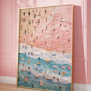 May include: A rectangular framed painting featuring a textured impasto beach scene. The upper section depicts a sandy shore in shades of pink and beige with numerous small figures, while the lower section shows blue ocean waves with surfboards.