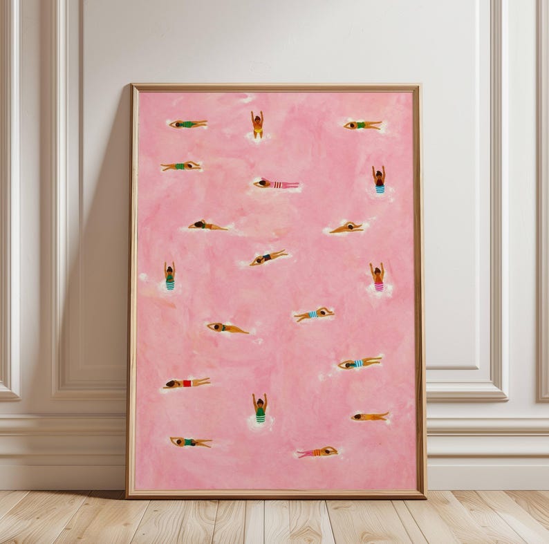 May include: A framed wall art print featuring a solid pink background with numerous small, stylized figures of swimmers in various poses, including diving and swimming, wearing colorful swimsuits in shades of blue, green, red, and yellow.