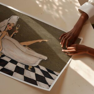 May include: A rectangular art print featuring a stylized painting of a figure in a white towel wrap and head turban, sitting in a bathtub while holding a glass of champagne. The floor has a black and white checkered pattern against a dark olive background.