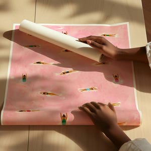 May include: A rectangular sheet of paper featuring a repeating pattern of small figures swimming in a pink, watercolor-style pool. The figures are depicted in various swimming poses, wearing colorful swimsuits against the soft pink background.