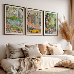 May include: Three watercolor paintings of New York City scenes. The first painting shows a park with a picnic blanket and a yellow taxi cab. The second painting shows a cityscape with a yellow taxi cab. The third painting shows a street scene with people sitting at a cafe.