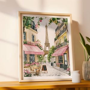 May include: A watercolor painting of a Parisian street scene with the Eiffel Tower in the background. The street is lined with pink-awninged cafes and blooming flowers.