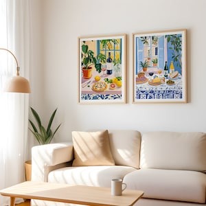 Puede incluir: Dos ilustraciones enmarcadas de una mesa puesta con comida y vino. La primera ilustraci&oacute;n presenta una pizza, una botella de vino, una copa de vino y una planta en maceta. La segunda ilustraci&oacute;n presenta una tabla de quesos con salami, aceitunas, pan y una copa de vino.