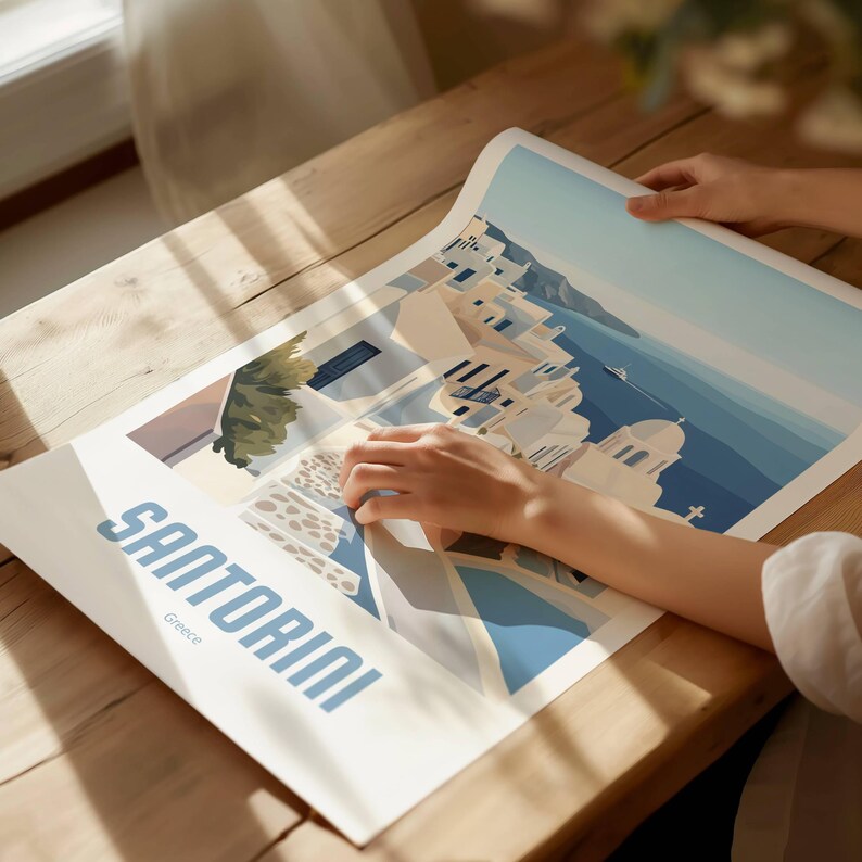 May include: A vintage travel poster featuring a colorful illustration of Santorini, Greece. The poster has a blue and white color scheme and features white buildings with blue accents, a blue sea, and a blue sky. The text "Santorini" is written in a bold, white font at the bottom of the poster.
