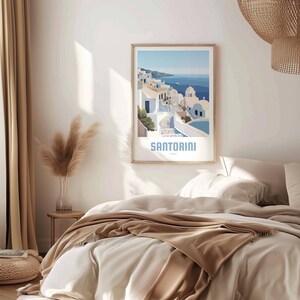 May include: A poster with a blue and white illustration of a town in Santorini, Greece. The poster has a white background with the word "SANTORINI" in blue text at the bottom.