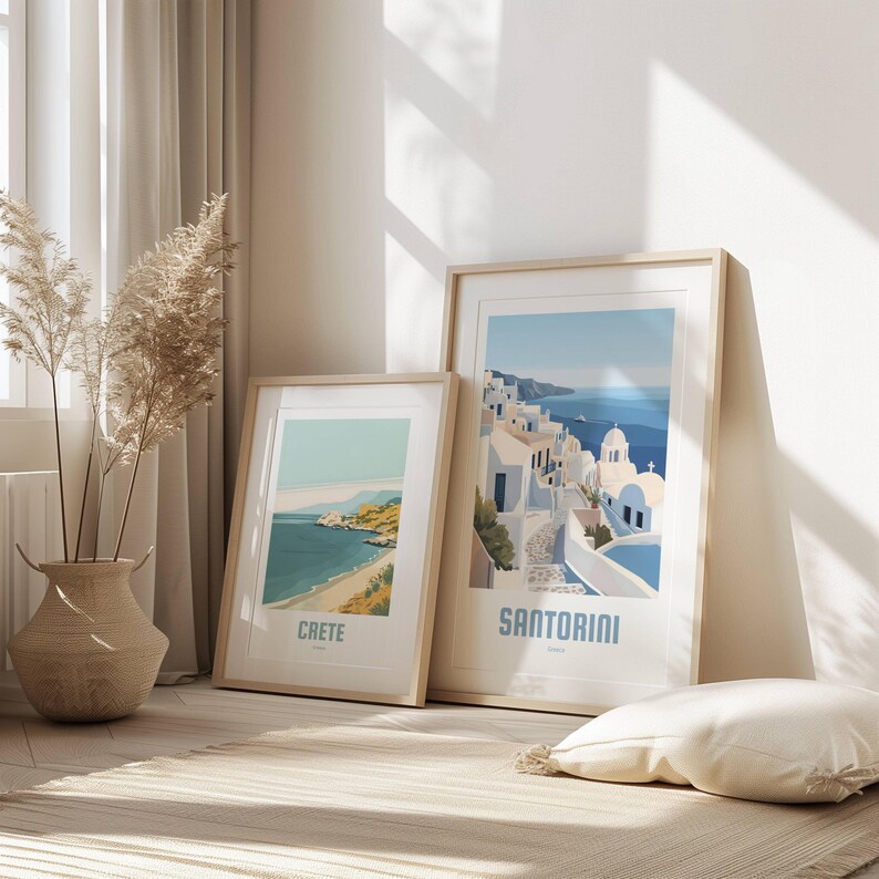 May include: Two framed prints of Greek islands. The print on the left shows a beach scene with the text "CRETE" below. The print on the right shows a white-washed village with the text "SANTORINI" below.