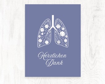 May include: A purple card with a white outline of lungs filled with white flowers. The text "Herzlichen Dank" is written in white cursive below the lungs.