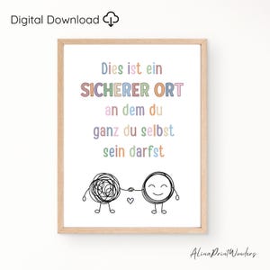 Può includere: Una stampa incorniciata con il testo tedesco "Dies ist ein sicherer Ort an dem du ganz du selbst sein darfst" in colori pastello. L'immagine presenta due personaggi dei cartoni animati che si tengono per mano, uno aggrovigliato, l'altro sorridente.