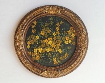 May include: An oval-shaped painting featuring a cluster of yellow flowers against a dark green background. The artwork is enclosed in an ornate, antique-style, gold-colored frame, adding a vintage aesthetic.