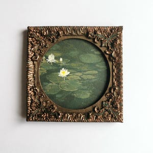 Small lotus flower painting inspired by nature and still water, framed in aged bronze style.