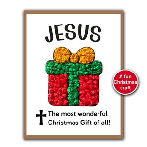 May include: A framed print featuring the word "JESUS" above a colourful gift box made of red, green, and yellow paper. The text "The most wonderful Christmas Gift of all!" is below the gift box, with a cross.