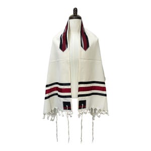 May include: White prayer shawl with black and red stripes and tassels. The shawl has a decorative pattern on the collar.