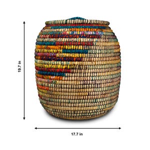 Puede incluir: Una cesta de almacenamiento tejida con tapa. La cesta mide aproximadamente 50 cm de alto y 45 cm de ancho. Presenta un colorido patr&oacute;n geom&eacute;trico en tonos rojos, amarillos, azules y verdes.