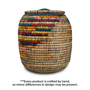 Puede incluir: Cesta tejida a mano de forma cil&iacute;ndrica. La cesta presenta una base beige natural con acentos tejidos coloridos en rojo, amarillo, azul y verde. El texto en la parte inferior dice: "***Cada producto est&aacute; hecho a mano, por lo que pueden existir ligeras diferencias de dise&ntilde;o."