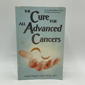 Puede incluir: Un libro titulado "The Cure for All Advanced Cancers" con una cubierta azul claro. La portada presenta el título en letras grandes y en negrita, con una ilustración de una mano sosteniendo una forma brillante. El nombre del autor está en la parte inferior.