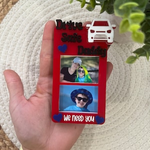 May include: Red photo frame with two pictures of children and the text "Drive Safe Daddy We Need You" with a blue heart on each side of the text. A white car icon is at the top of the frame.
