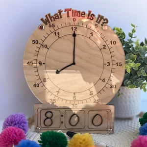K&ouml;nnte beinhalten: Eine Holzuhr mit einem klaren Zifferblatt und schwarzen Zeigern. Die Uhr ist auf 8:00 Uhr eingestellt. Die Uhr hat ein digitales Display darunter, das ebenfalls 8:00 Uhr anzeigt.