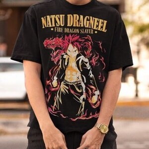Peut inclure: T-shirt noir avec un imprimé graphique d'un personnage d'anime aux cheveux roux avec un dragon et le texte "Natsu Dragneel - Fire Dragon Slayer".
