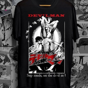 May include: Black t-shirt with a white graphic of a character from the anime Devilman. The graphic features the character in a demonic form with the text "Devilman" above it and "Step inside, see the devil in I" below it.