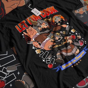 Peut inclure: T-shirt noir avec une illustration de deux personnages de type viking en train de cuisiner. Le texte "Let Him Cook" est au-dessus des personnages. Le texte "Delicious in Dungeon" est en dessous des personnages.