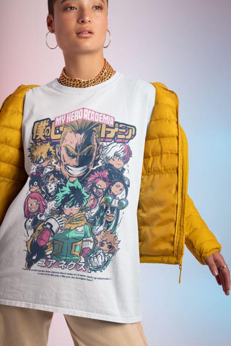 May include: White t-shirt with a graphic print of characters from the anime My Hero Academia. The graphic features the text "My Hero Academia" and Japanese characters. The characters are depicted in a colorful, comic book style.