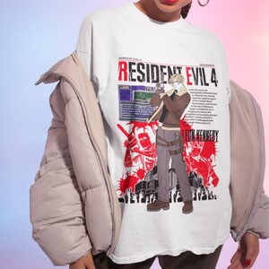 May include: White t-shirt featuring a graphic print of Leon S. Kennedy from Resident Evil 4. The graphic is in red and black and includes the text "Resident Evil 4" and "Leon S. Kennedy".