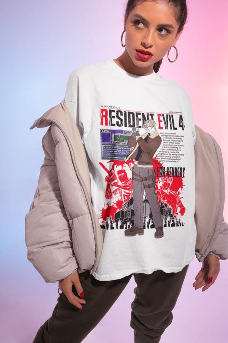 May include: White t-shirt featuring a graphic print of Leon S. Kennedy from Resident Evil 4. The graphic is in red and black and includes the text "Resident Evil 4" and "Leon S. Kennedy".