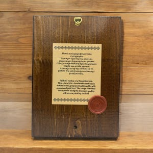 Back side of a handmade natural wood icon with silkscreen print on canvas, featuring a description of the crafting technique and a quality seal.