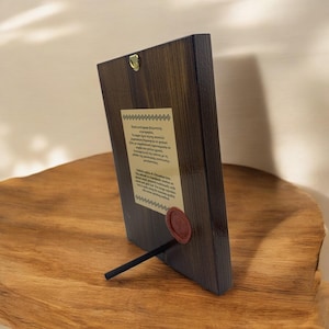 Back side of a handmade natural wood icon with silkscreen print on canvas, featuring a description of the crafting technique and a quality seal.