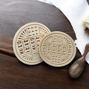 May include: Two wooden round stamps with intricate designs. The larger stamp features the words "MUKDA" and "MISRA" in a circular pattern. The smaller stamp features the words "SAKSHAM" and "MUKDA" in a circular pattern.