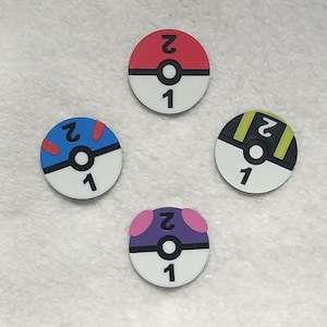 May include: Four circular tokens featuring a stylized design resembling a ball with a central horizontal black line and a white circle. Each token displays the number 2 on the top half and the number 1 on the bottom half in black font.