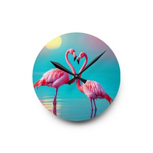 May include: Round wall clock featuring two pink flamingos with their necks intertwined, forming a heart shape. The clock face has a turquoise background with a yellow sun and black clock hands.