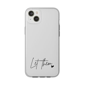 May include: A clear phone case with a white background. The words "Let them" are written in a black script font, followed by a small black heart. The case has a camera cutout and side buttons.