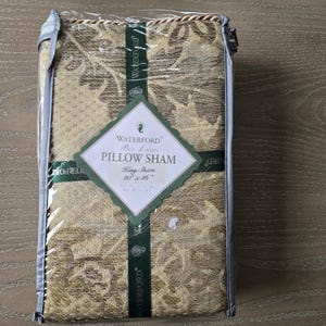 May include: A packaged Waterford Bed Linens King Sham, 20" x 36", in a gold and beige floral pattern. The pillow sham is wrapped in clear plastic and has a tag with the brand name and product details.