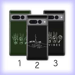 Könnte beinhalten: Drei Handyhüllen mit verschiedenen Designs. Die erste Hülle ist grün mit einer weißen Umrandung von zwei Händen, die das Friedenszeichen machen. Die zweite Hülle ist schwarz mit einer weißen Umrandung von zwei Händen, die einen Joint weitergeben. Die dritte Hülle ist schwarz mit einer weißen Umrandung von zwei Händen, die das Friedenszeichen machen und dem Text "VIBES".