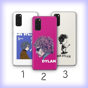 May include: Three different phone cases featuring Bob Dylan. The first case has a photo of Bob Dylan from the album "Mr. Tambourine Man". The second case has a colorful illustration of Bob Dylan's face. The third case has a cartoon illustration of Bob Dylan playing a guitar.