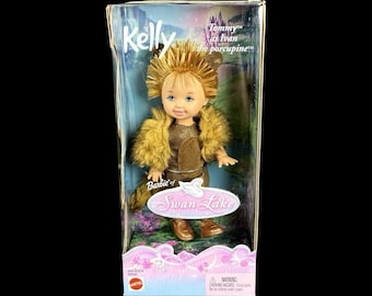 Peut inclure: Une poupée Kelly dans son emballage d'origine, déguisée en Ivan le porc-épic du Lac des Cygnes. La poupée a des cheveux dorés en épis, une tenue brune texturée avec une bordure en fausse fourrure et des chaussures brunes. La boîte porte le texte Kelly, Tommy as Ivan the porcupine et Swan Lake.