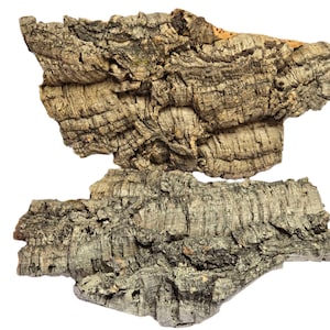 May include: Two pieces of natural cork bark, showcasing a textured, layered appearance. The bark displays a mix of gray, brown, and tan hues, with visible ridges and crevices. The organic shapes are set against a clean white background.