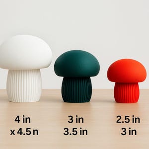 Könnte beinhalten: Drei pilzförmige Dekorationsgegenstände in Weiß, Teal und Rot. Der weiße Pilz ist 10 cm hoch und 11,4 cm breit. Der teal-farbene Pilz ist 7,6 cm hoch und 8,9 cm breit. Der rote Pilz ist 6,4 cm hoch und 7,6 cm breit.
