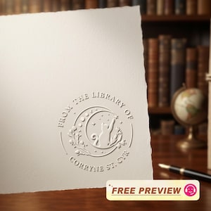 May include: Cream-colored paper with an embossed circular design featuring a cat reaching for a star within a crescent moon. The text reads "FROM THE LIBRARY OF CORRYNE ST. CYR." A "FREE PREVIEW" sticker is at the bottom.