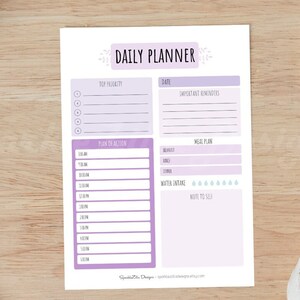 May include: A printable daily planner with a purple and white watercolor design. The planner includes sections for top priority tasks, important reminders, a plan of action, meal plan, water intake, and notes to self.