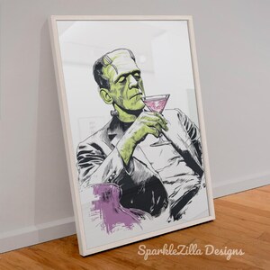 Frankenstein with martini cocktail illustrated in vintage style, framed printable leaning against wall on wooden floor.