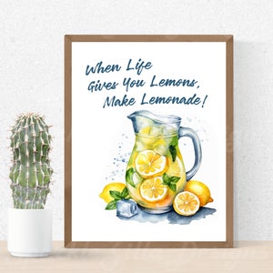 Puede incluir: Una ilustración de acuarela de una jarra de limonada con limones y cubitos de hielo. El texto "When life gives you lemons, make lemonade!" está escrito en azul sobre un fondo blanco.