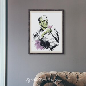 Frankenstein with martini wall art framed on white wall with sunlight and plants, vintage retro Halloween decor.