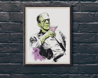 May include: Framed art print featuring a stylized illustration of Frankenstein's monster holding a cocktail. The artwork is in black, white, and green, with a splash of purple. The print is set against a dark brick wall. The text "SparkleZilla Designs" is at the bottom.