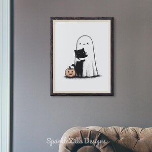 Cute ghost hugging cat printable Halloween wall art above sofa.